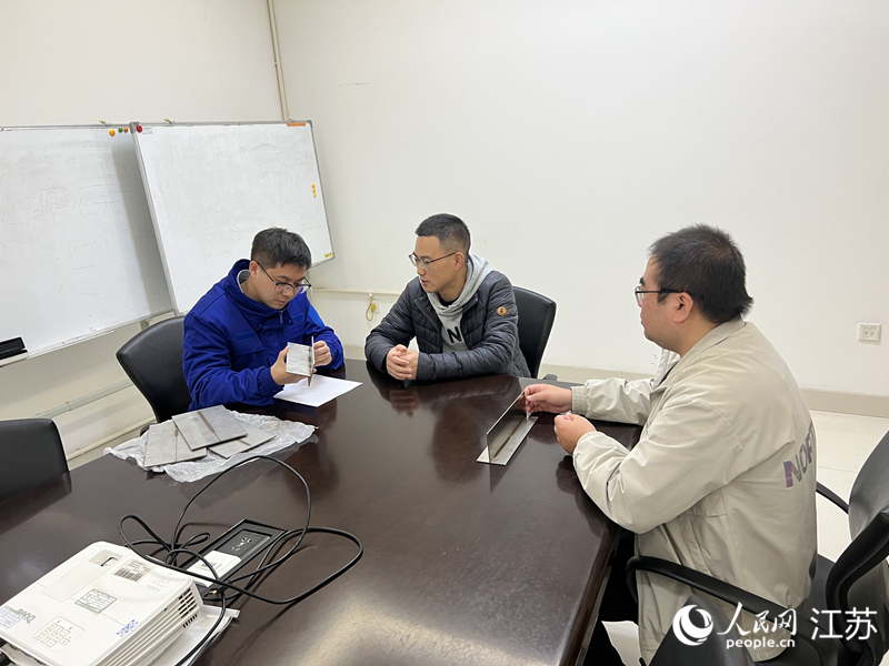 張濤（中）和企業(yè)溝通技術(shù)細(xì)節(jié)。人民網(wǎng) 江楠攝